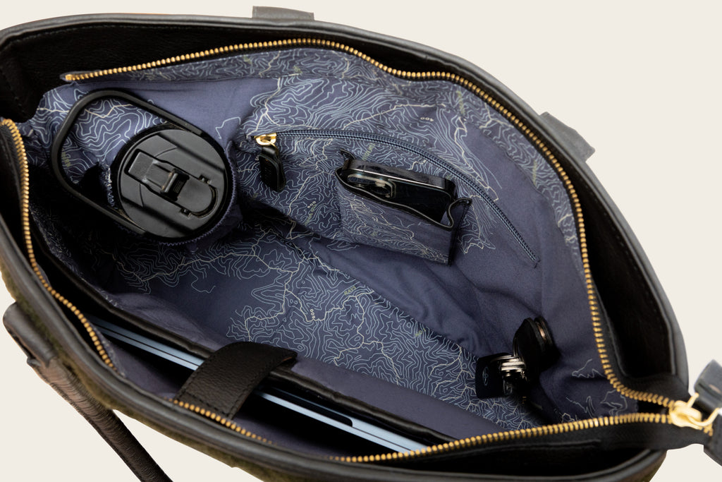 A green quilted mini tote bag with wool materia featuring a structured design and a signature map-lined cotton interior product