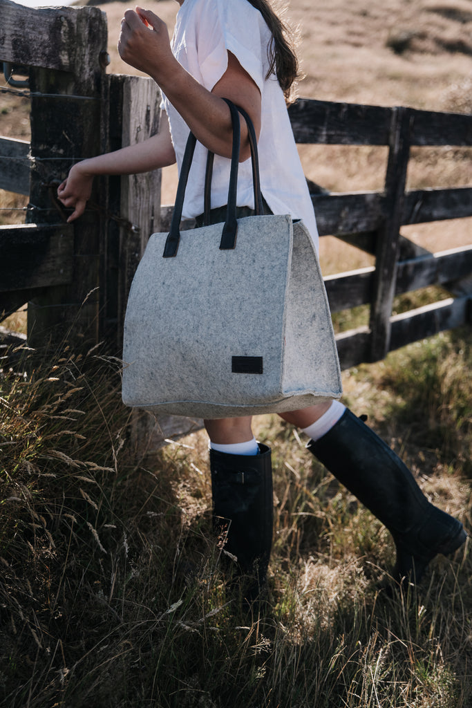 Person holding The Honest Wolf gray Casual Shopper with black handles in a natural setting