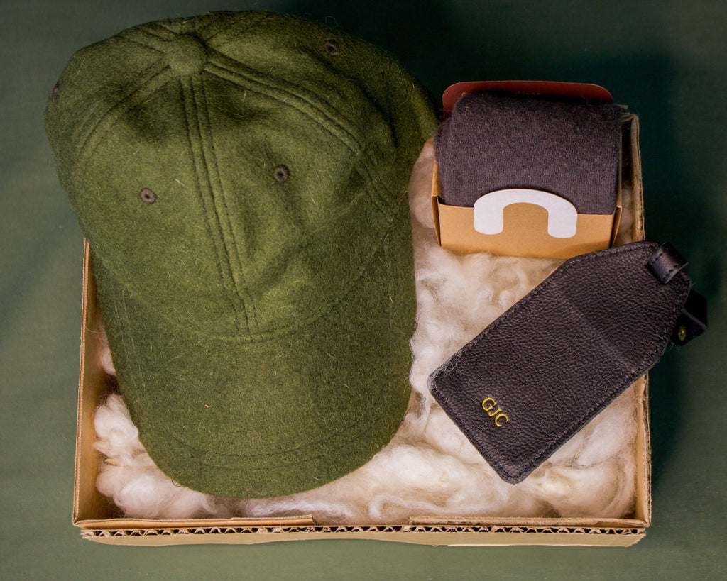 Honest Wolf Green wool cap, black leather luggage tag, and wool socks in a father's day gift box