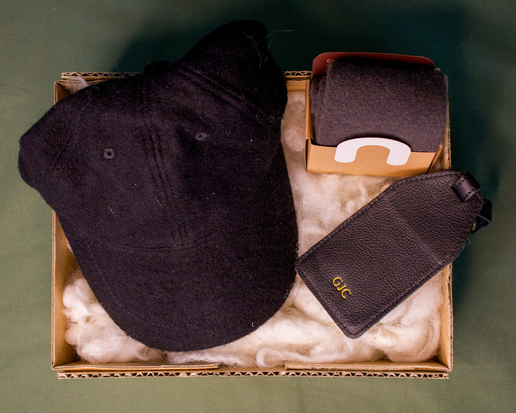 Honest Wolf black wool cap, black leather luggage tag, and wool socks in a father's day gift box