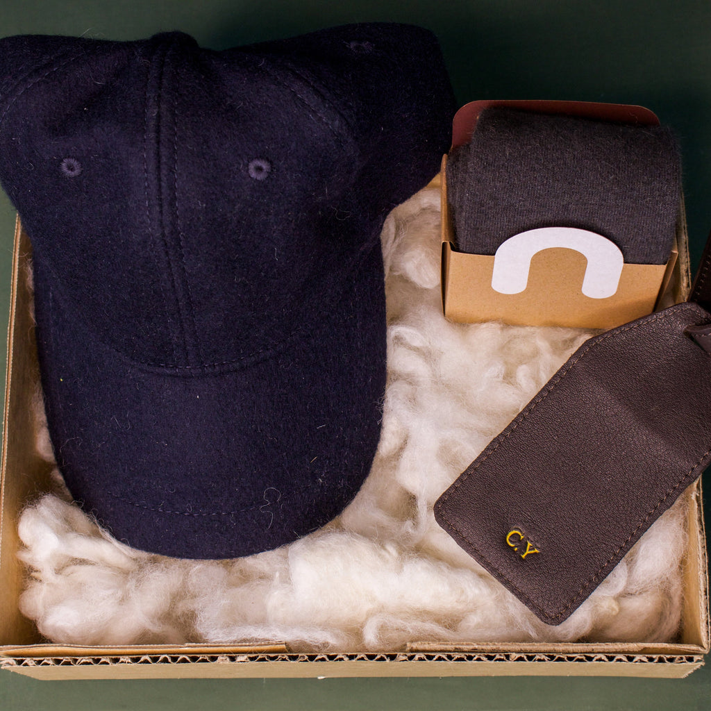 Honest Wolf navy wool cap, brown leather luggage tag, and wool socks in a father's day gift box