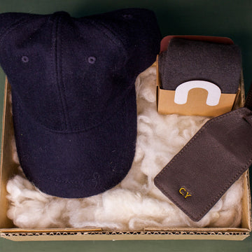 Honest Wolf navy wool cap, brown leather luggage tag, and wool socks in a father's day gift box