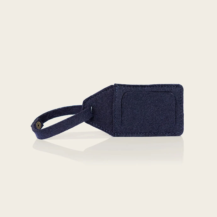 Navy blue luggage tag on a light beige background